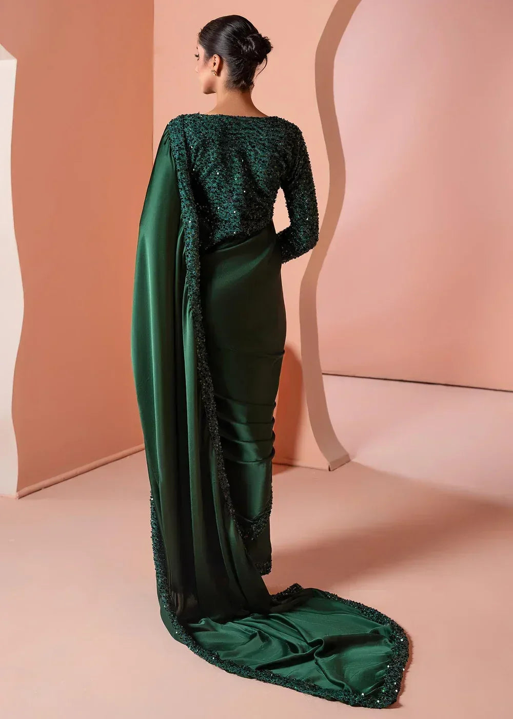 Woman in elegant dark green sequin saree with draped pallu, stylish textile fashion