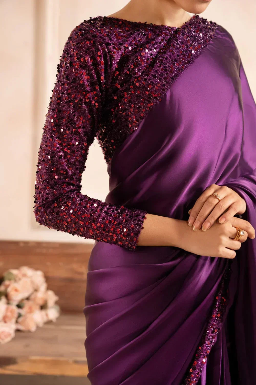 Woman wearing elegant purple sequin embellished saree with long sleeves, stylish formal fabric