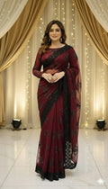 Woman in maroon and black embroidered saree, elegant draped backdrop, Sareeium jan style