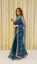 Woman in elegant blue embroidered saree posing indoors, Sareeium jan fashion collection