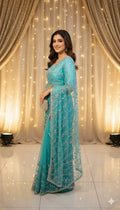 Woman in blue embroidered saree posing at Sareeium jan event with golden backdrop lights