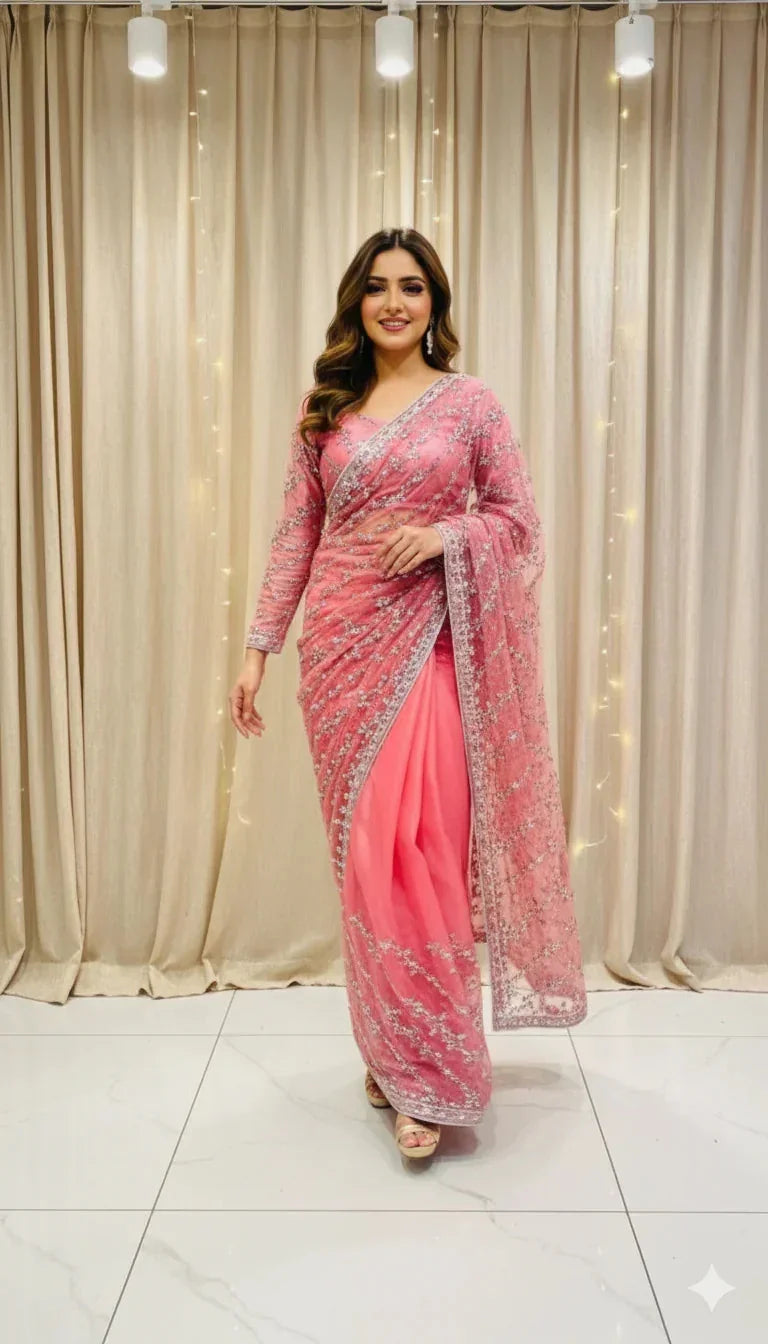 Woman in elegant pink embroidered saree posing indoors with beige curtains, Sareeium jan