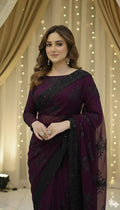 Woman in elegant purple embroidered saree posing indoors with golden drape backdrop, Sareeium jan