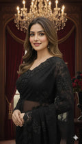 Woman in elegant black saree posing indoors with chandelier and red drapes, Sareeium jan style
