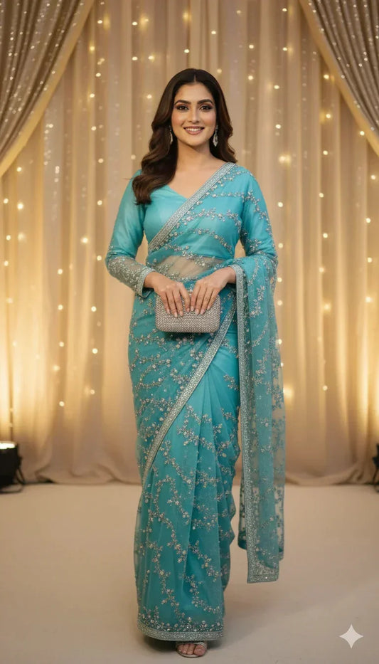 Woman wearing an elegant blue embroidered saree, holding a silver clutch, with glowing backdrop