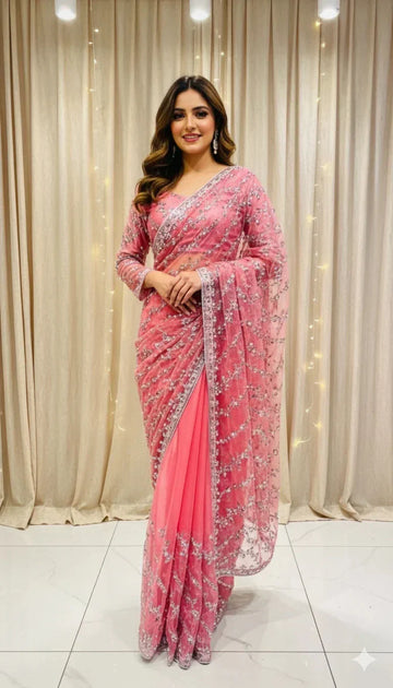 Woman in elegant pink embroidered saree standing indoors, perfect for Sareeium jan collection