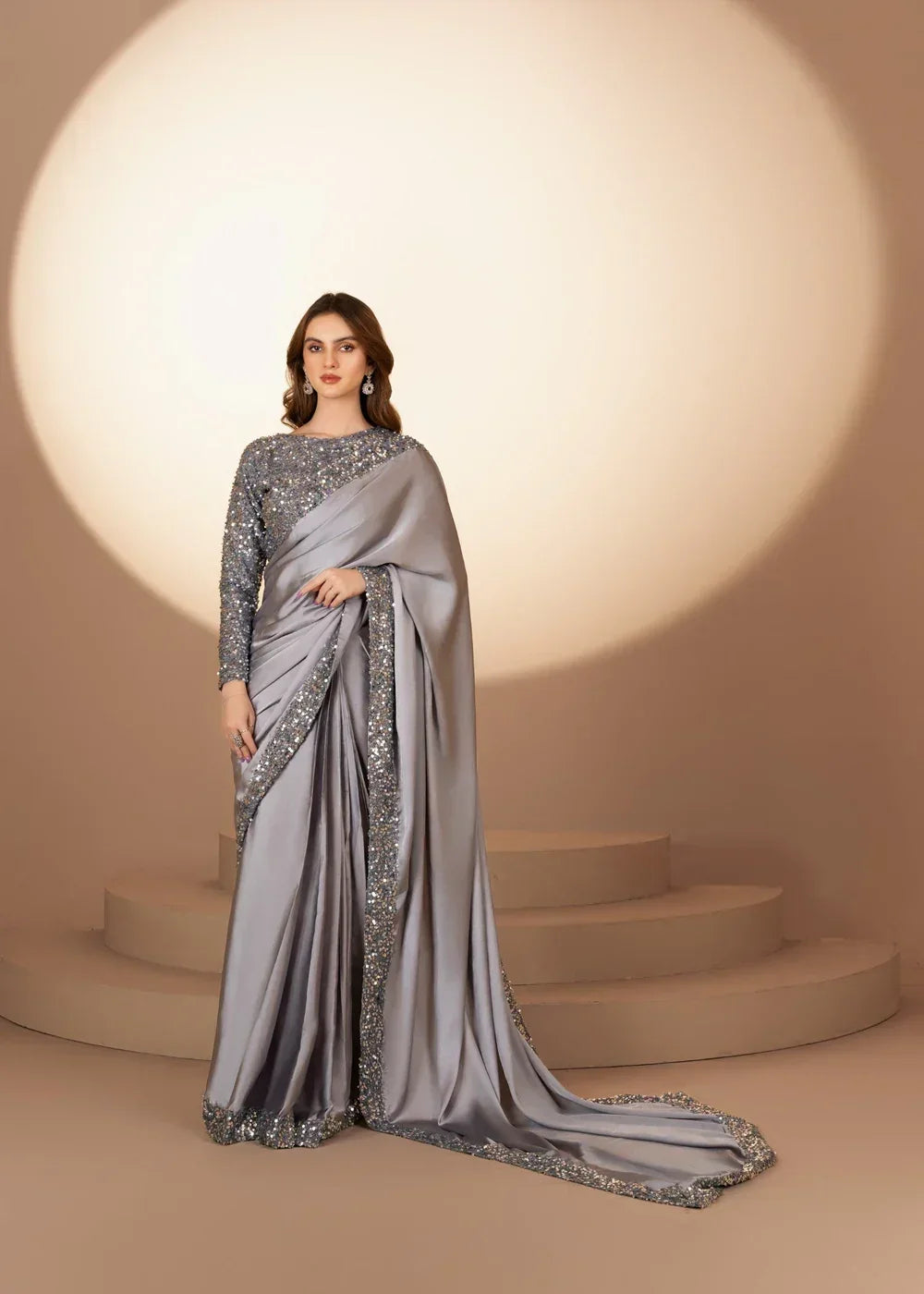 Woman wearing silver sequin embellished saree with long sleeves, evening wear fashion