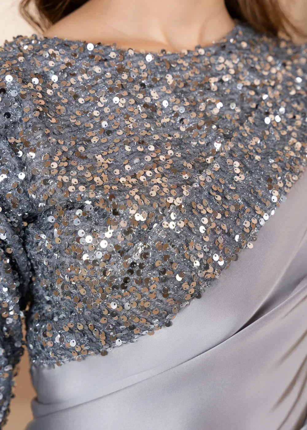 Close-up of silver sequin fabric with satin detailing, elegant shiny textile for dresses