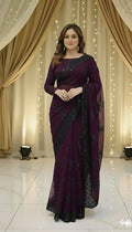 Woman in elegant purple saree with black floral design at Sareeium jan event, festive backdrop